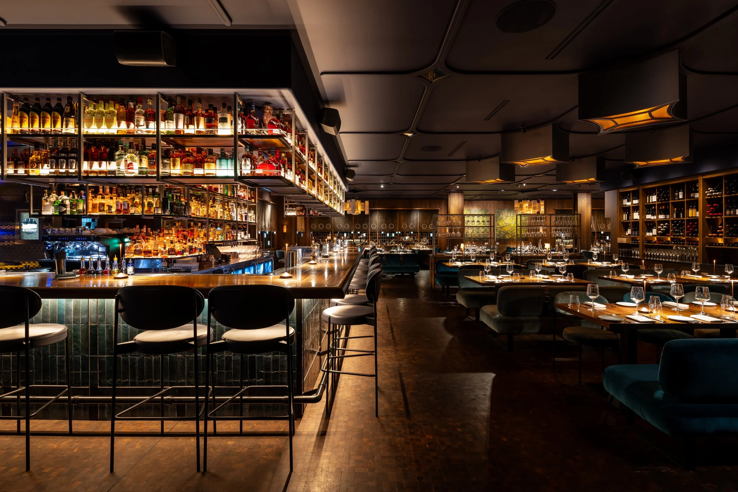 The Wild Blue bar and dining room, lit bottle shelves behind the long bar